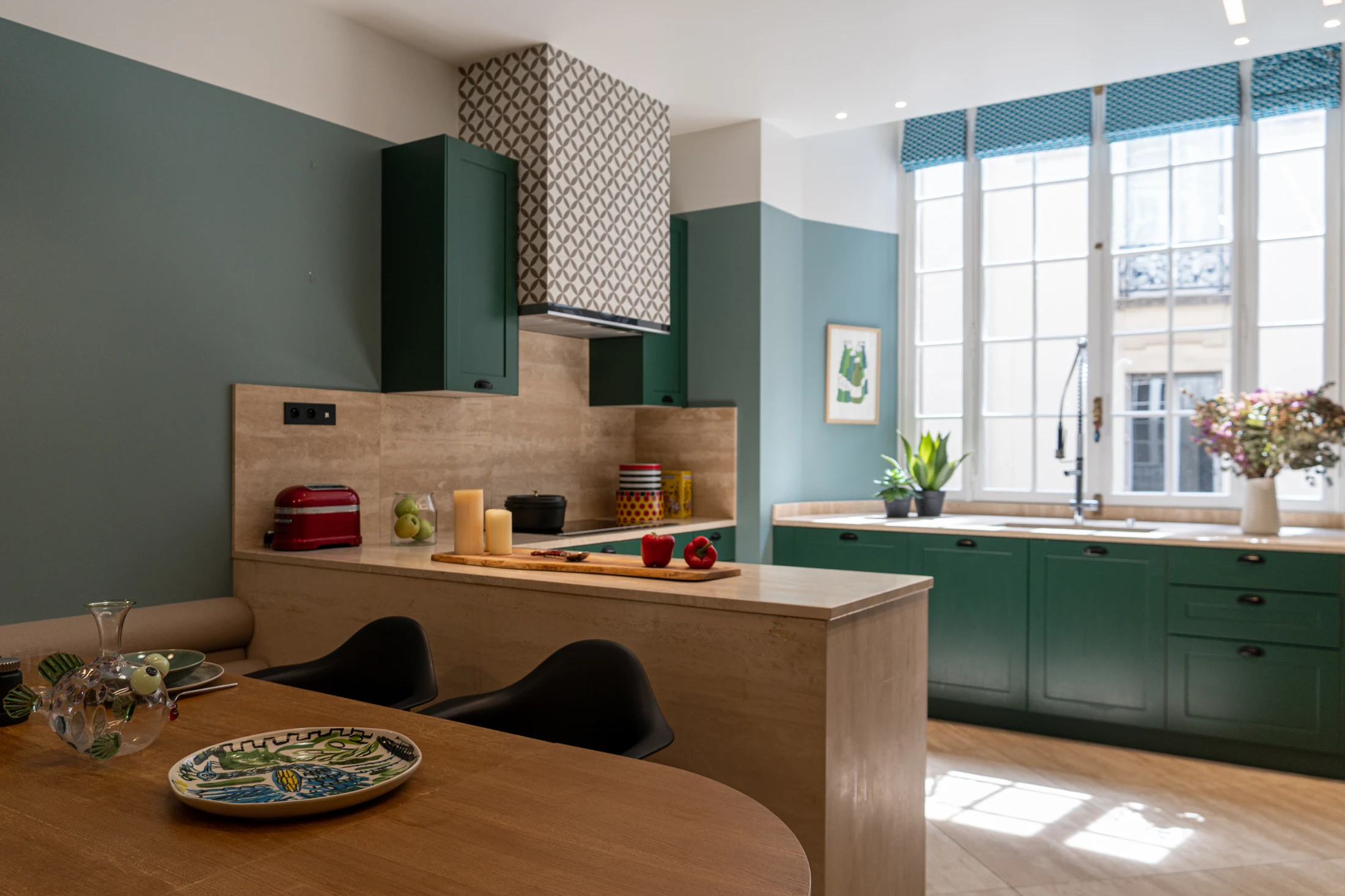 Cuisine aménagée avec façades vertes, bois clair et coin repas