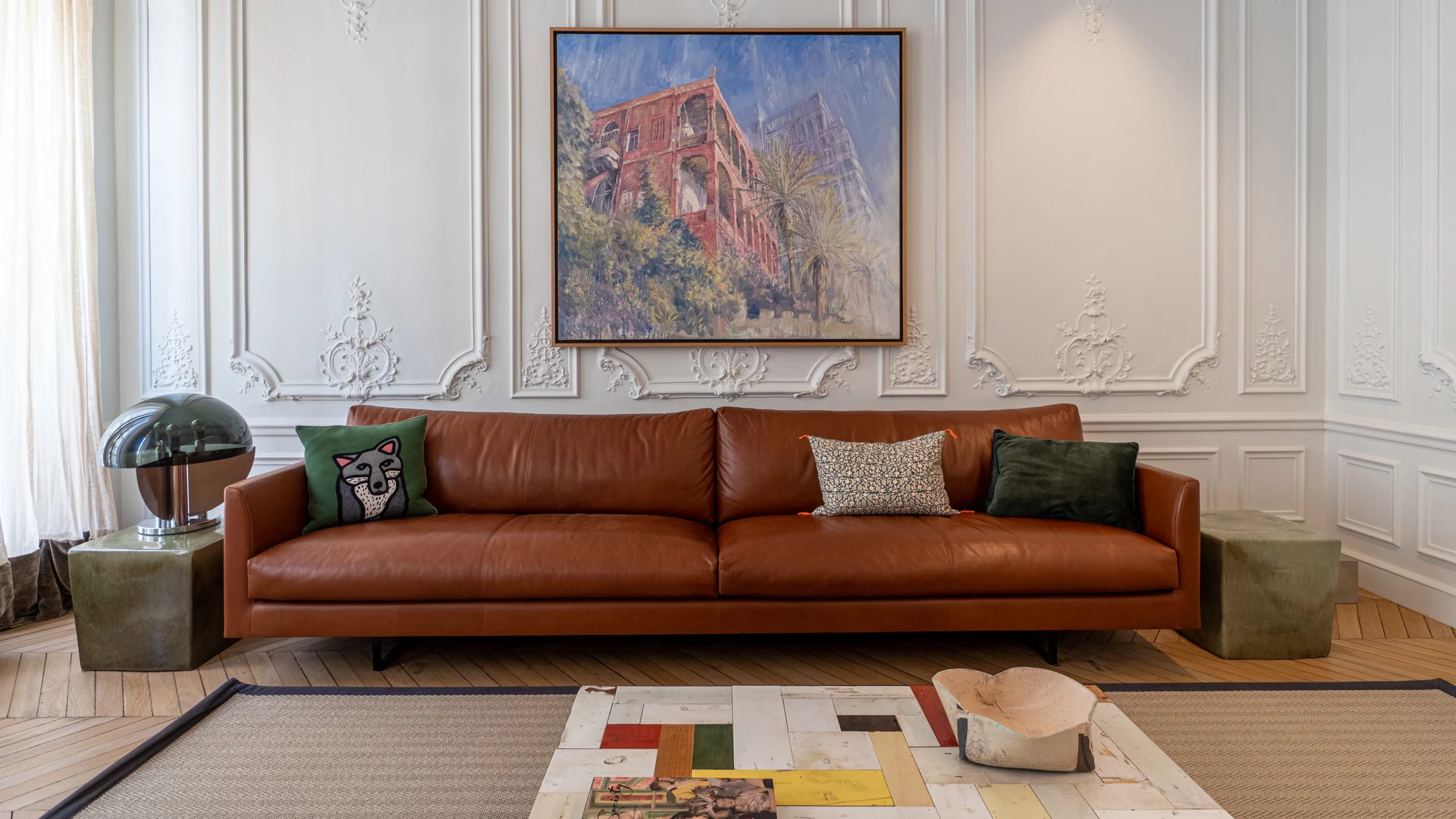 Espace séjour rénové avec parquet, moulures et canapé en cuir